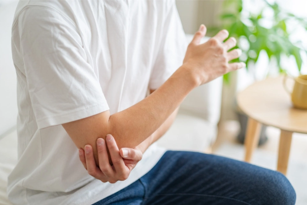 A person in a white tshirt sitting on a couch
